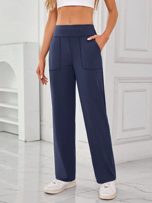 Person wearing navy blue high-waisted pants with a white background