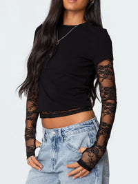 Black crop top with lace sleeves worn by a person on a white background