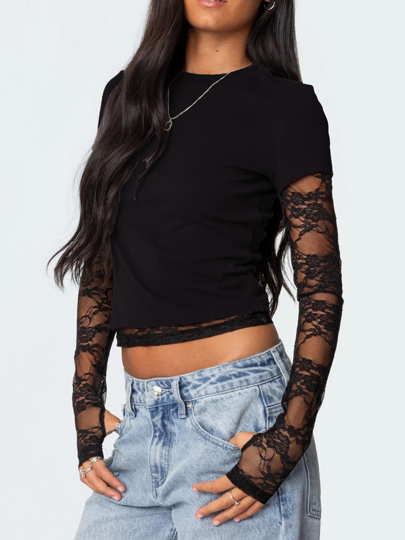Black crop top with lace sleeves worn by a person on a white background
