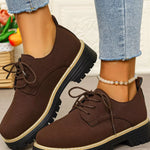 Brown suede shoes worn with light blue jeans on a neutral background