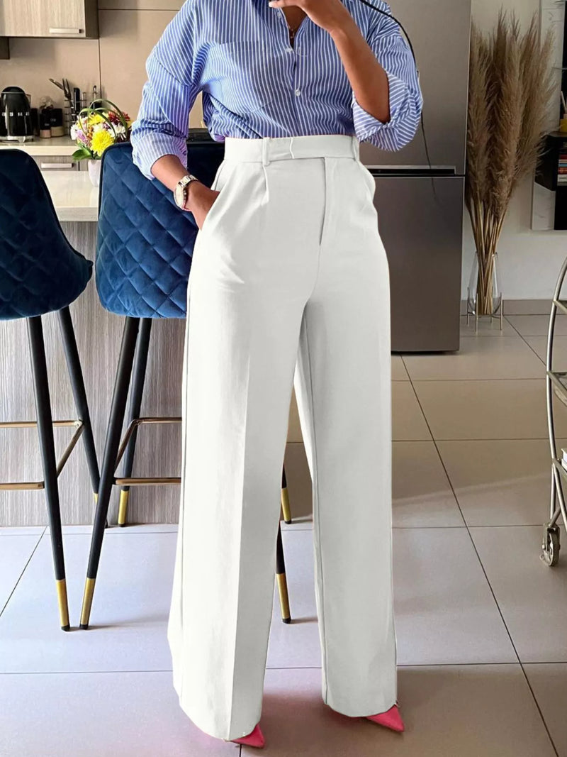 Person wearing a blue striped shirt and white pants in a kitchen setting