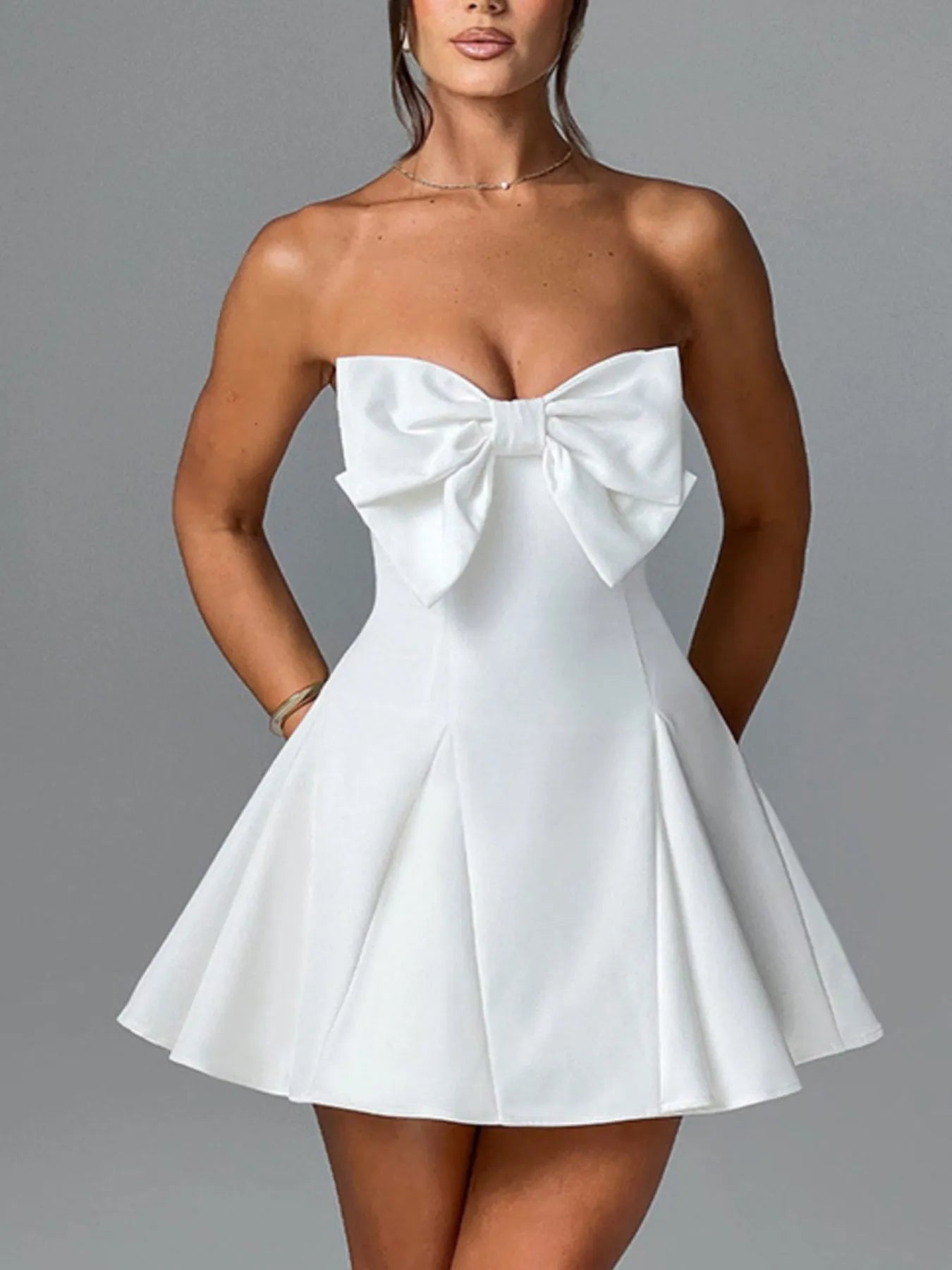 White strapless dress with a large bow detail on a gray background