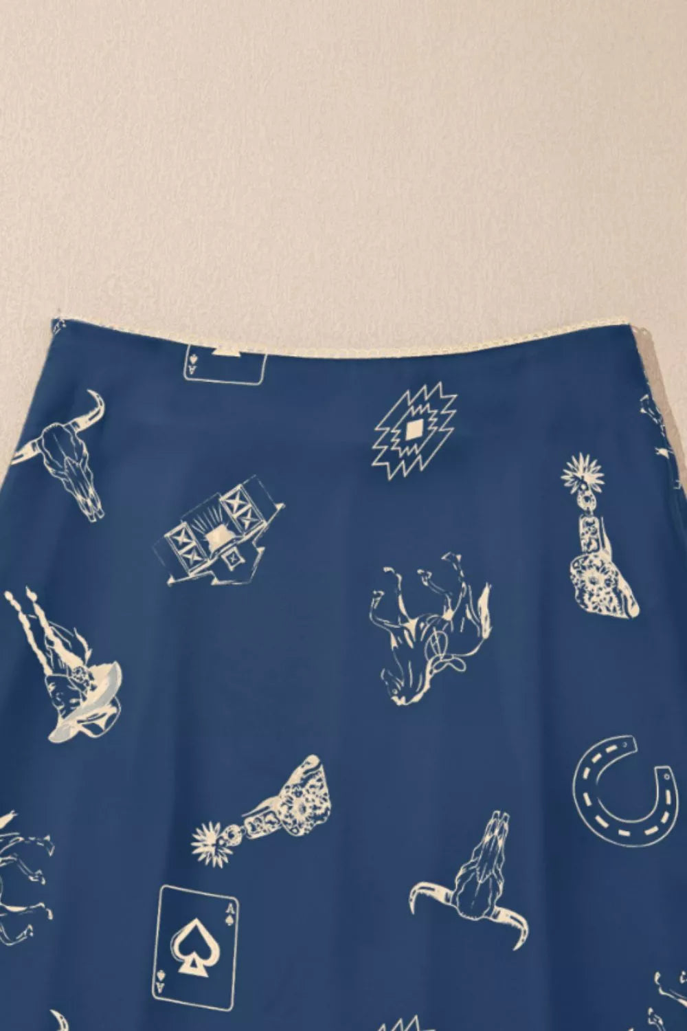 Blue fabric with white graphic designs on a beige background
