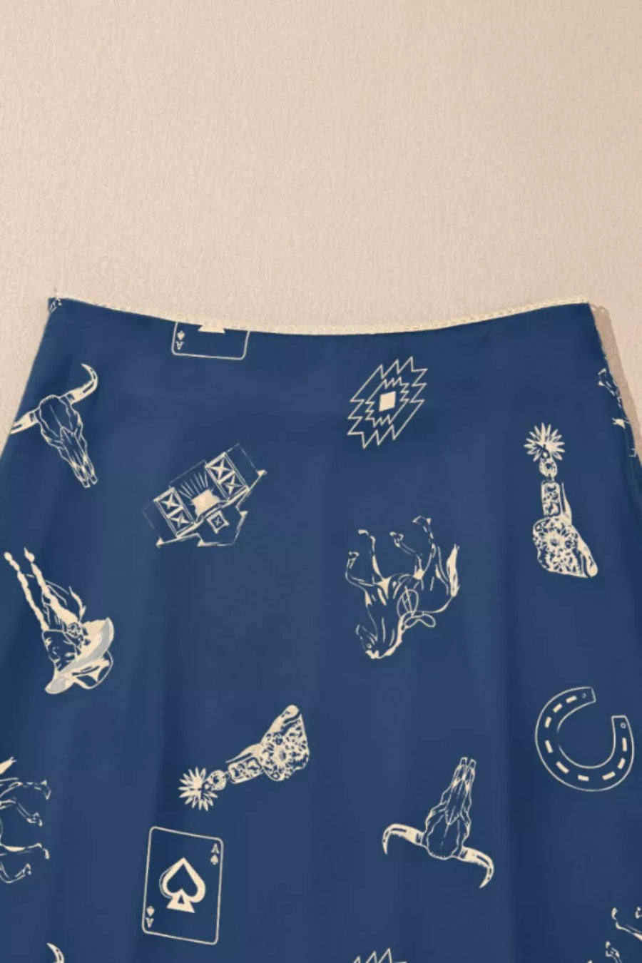 Blue fabric with white graphic designs on a beige background
