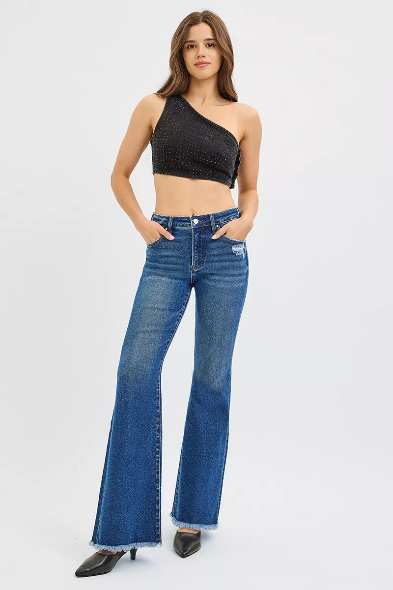 Woman wearing a black one-shoulder top and blue jeans on a white background