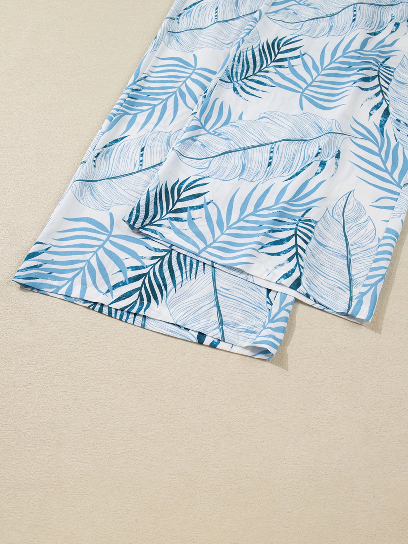 Blue leaf-patterned fabric on a beige background