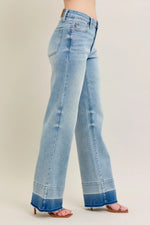 Light blue jeans worn by a person on a beige background
