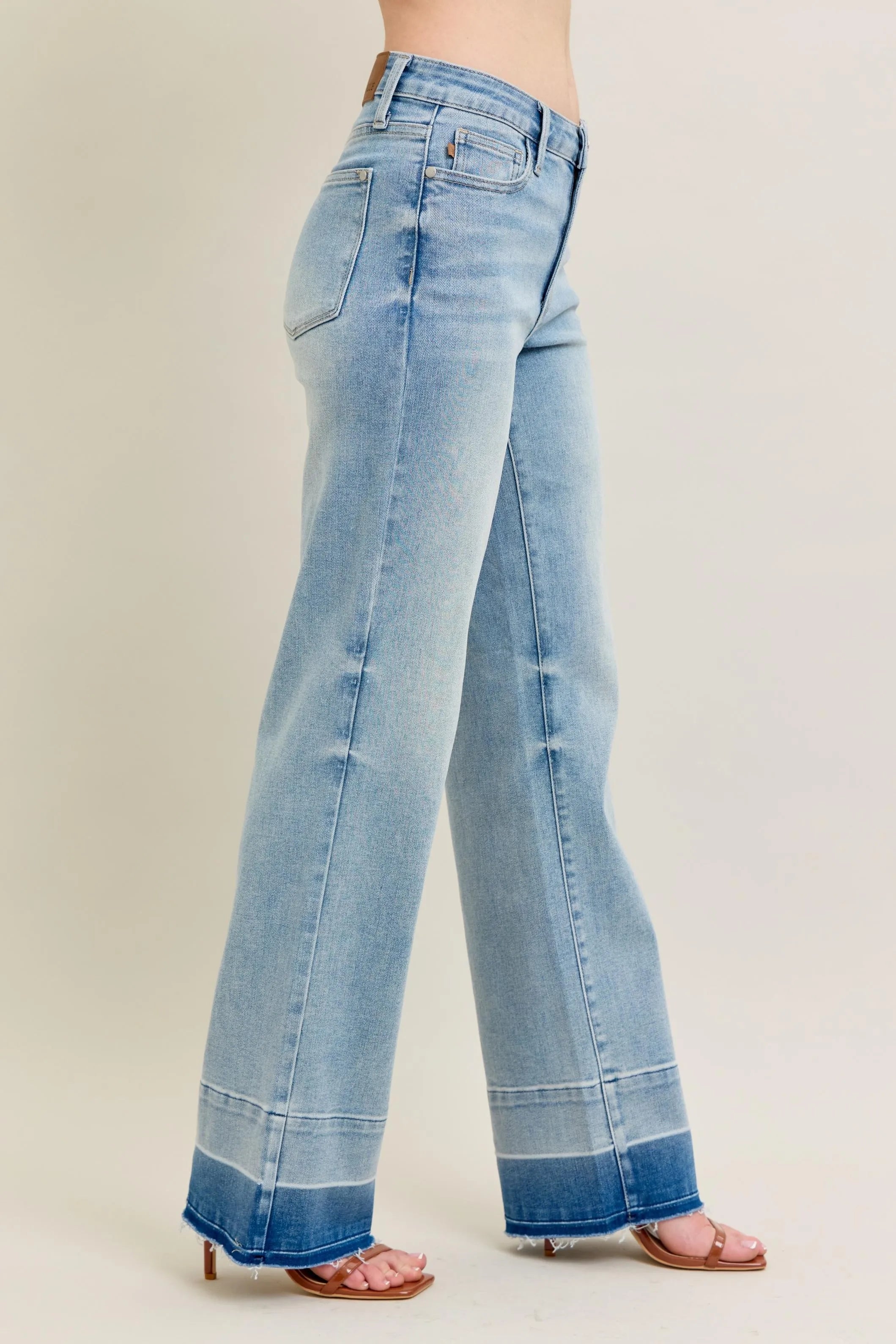 Light blue jeans worn by a person on a beige background