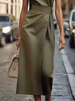 Person wearing a green dress on a street with blurred background