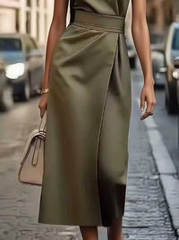 Person wearing a green dress on a street with blurred background