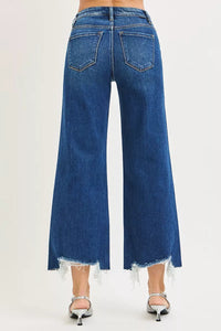 Blue jeans with fringe at the bottom on a white background
