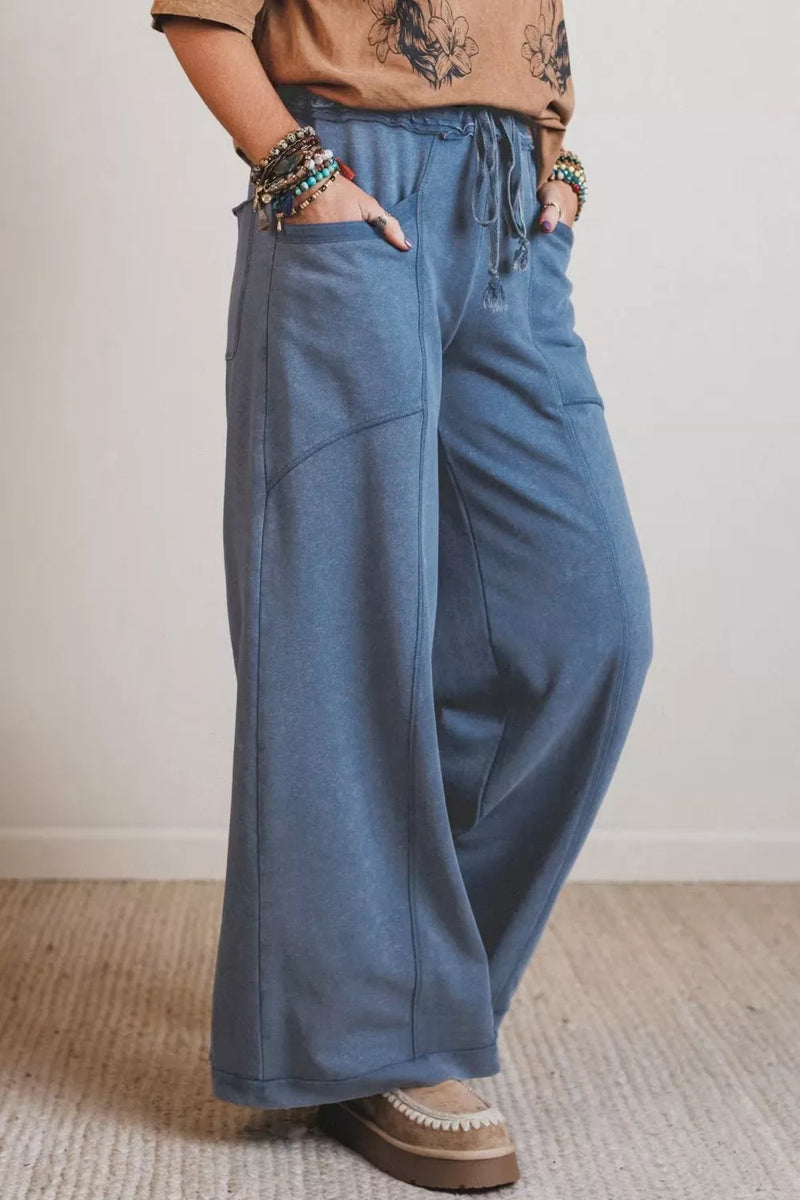Person wearing blue wide-leg pants with a neutral background