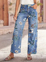 Person wearing blue floral jeans standing on a street.