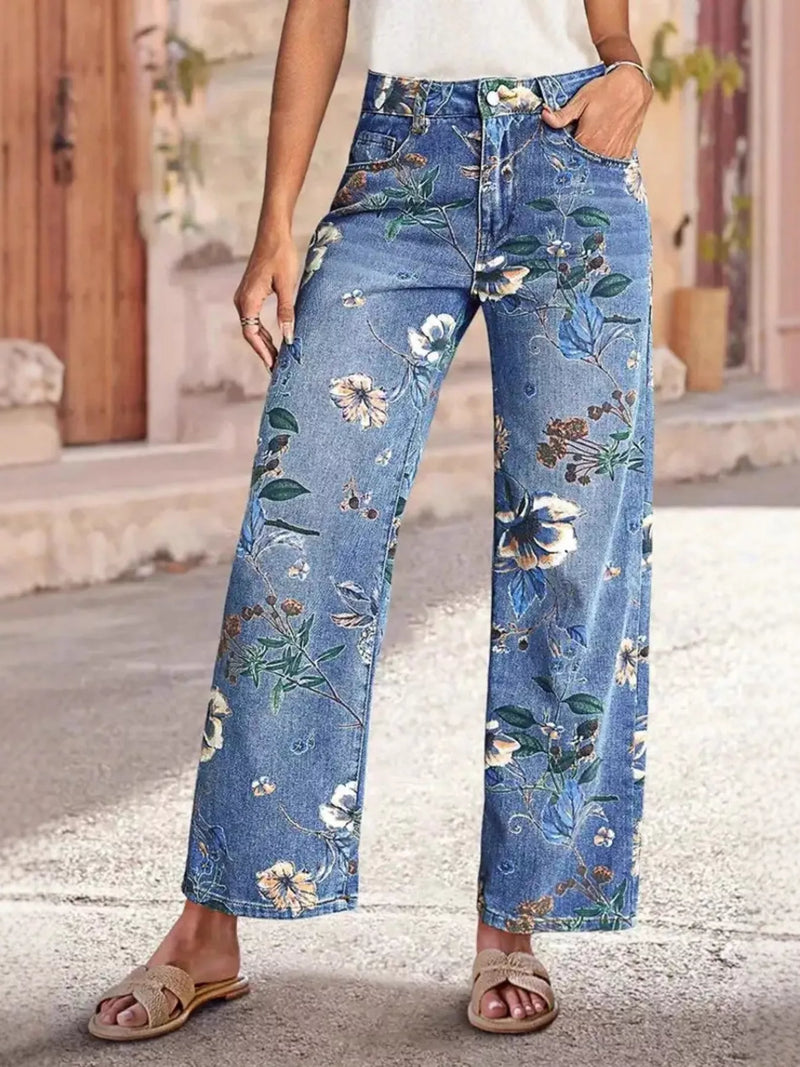 Person wearing blue floral jeans standing on a street.