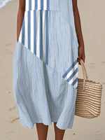 Person wearing a blue and white striped dress on a beach.