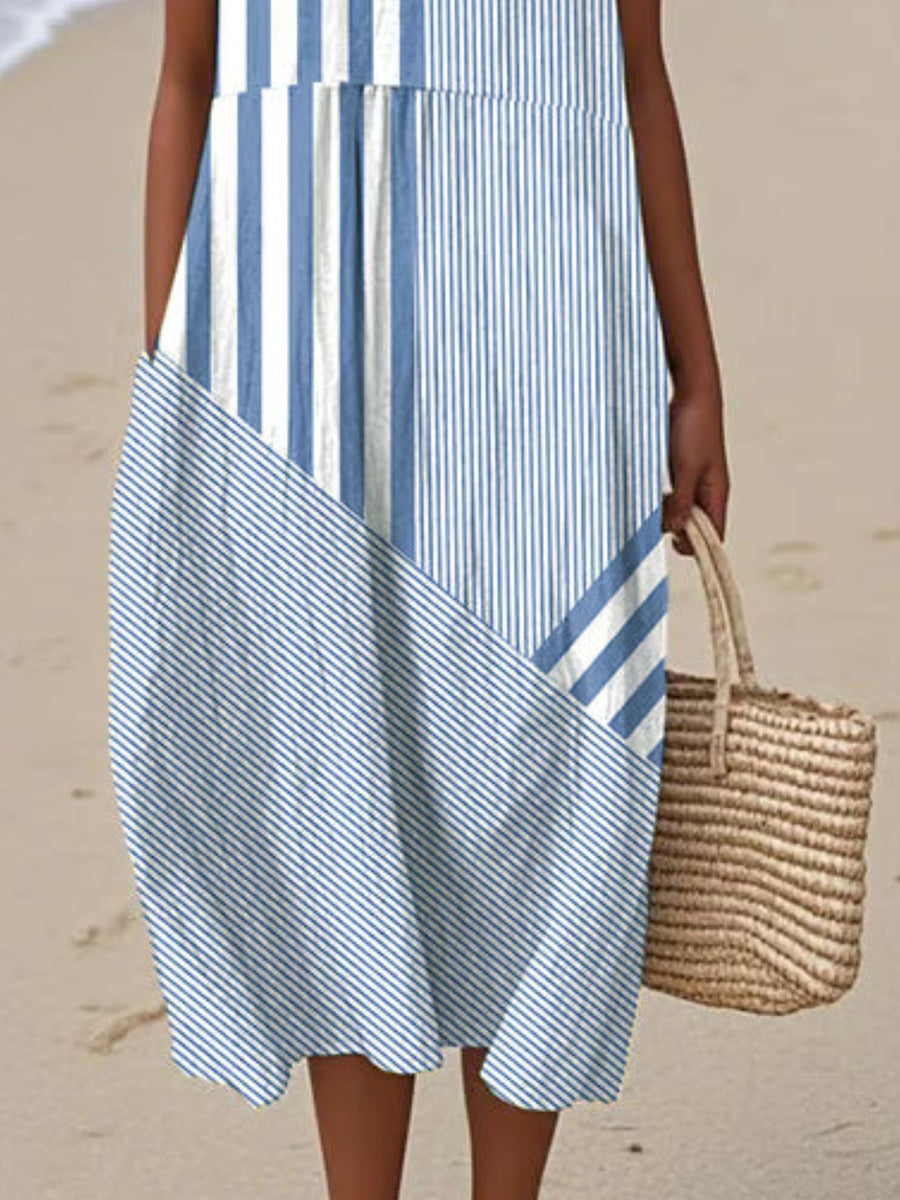 Person wearing a blue and white striped dress on a beach.