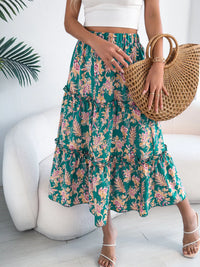 Person wearing a floral skirt and holding a woven handbag indoors.