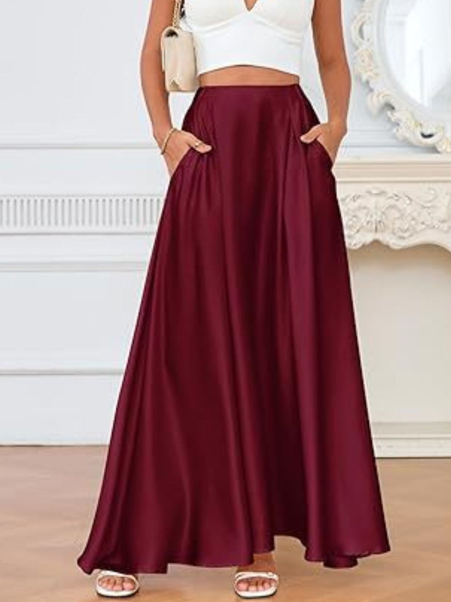 Person wearing a burgundy skirt with a white top and sandals indoors.