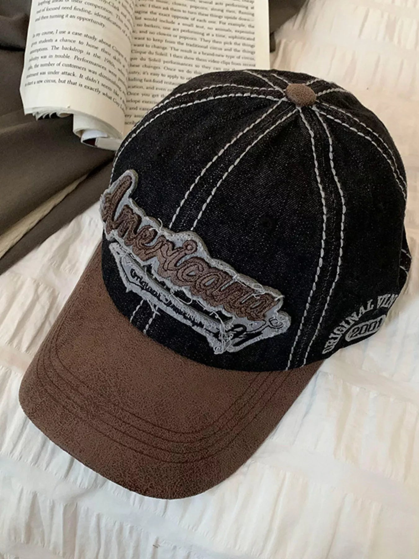 Black and brown cap with 'American' logo on a textured surface
