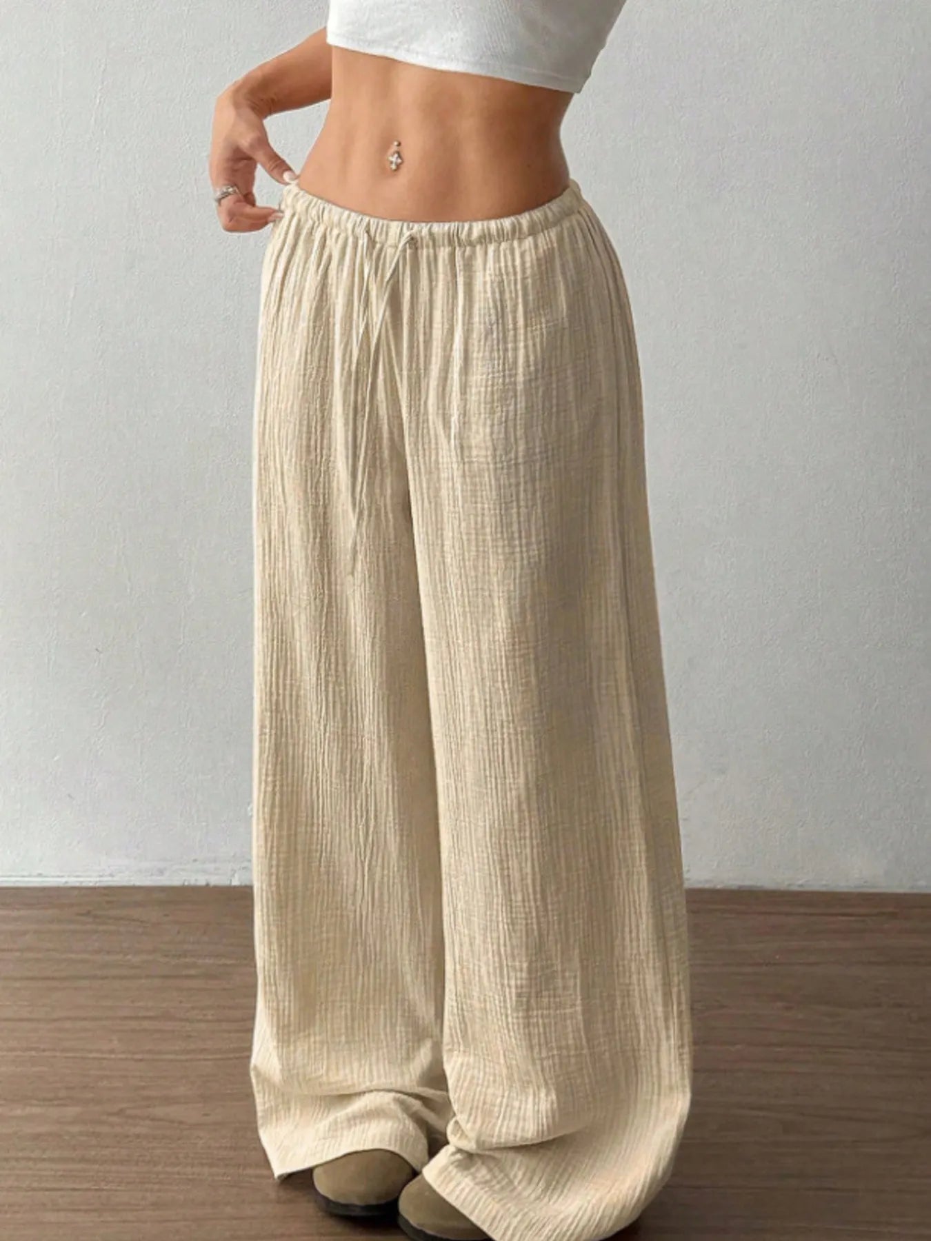 Beige wide-leg pants worn by a person on a plain background