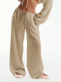 Beige wide-leg pants worn by a person on a white background