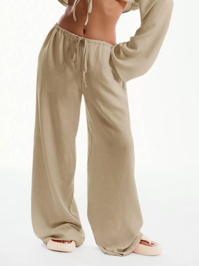 Beige wide-leg pants worn by a person on a white background