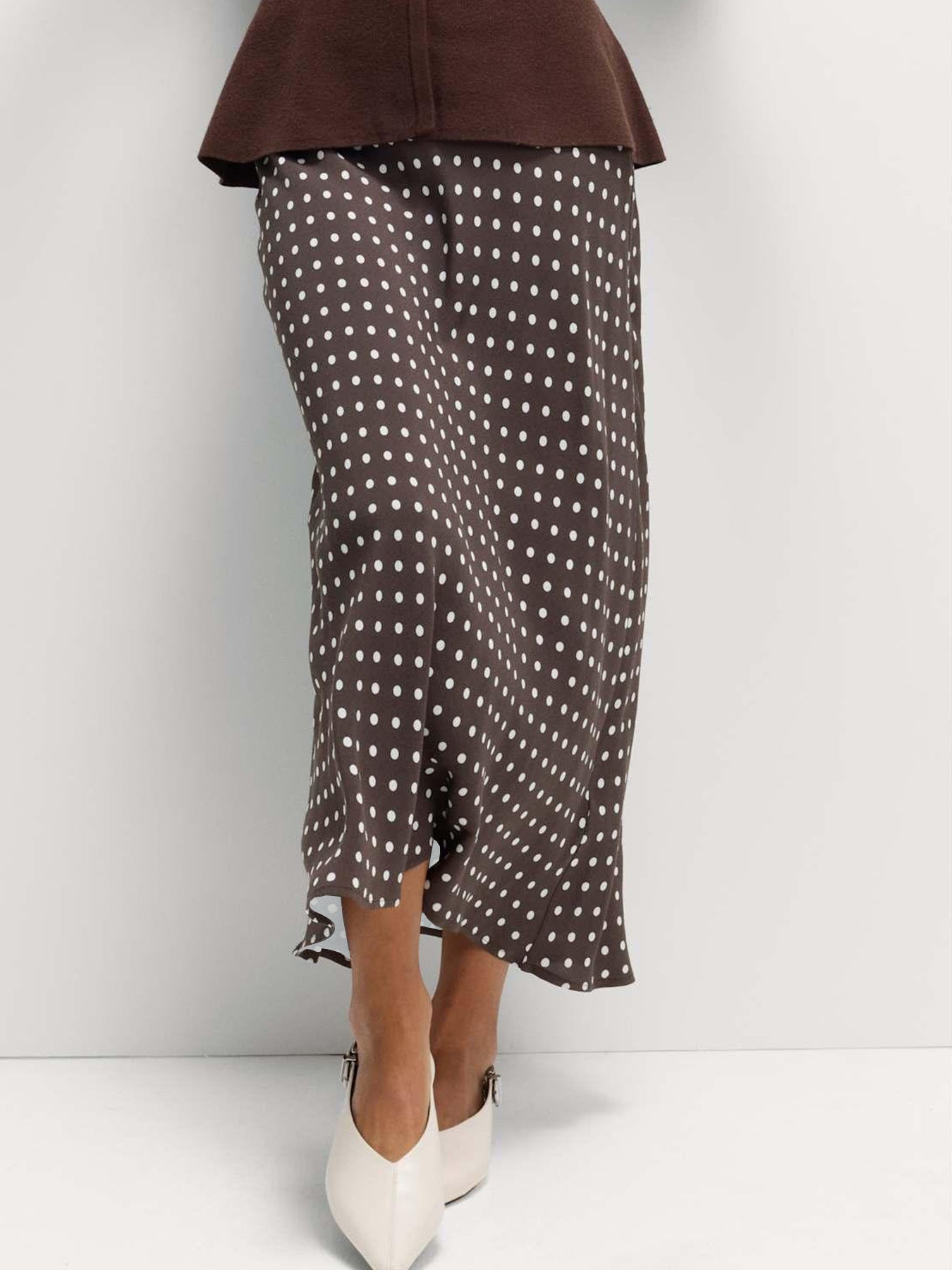 Brown polka dot skirt worn by a person on a white background