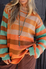 Person wearing a striped sweater with orange, green, and brown colors.