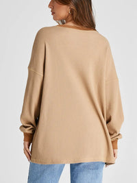 Beige sweater worn by a person on a white background
