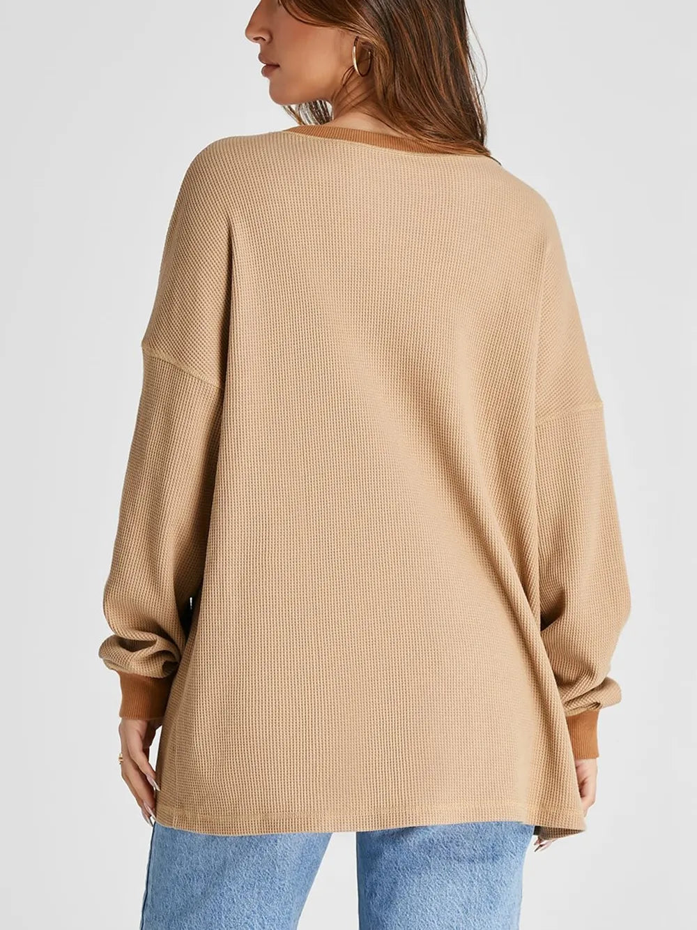 Beige sweater worn by a person on a white background
