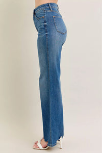 Blue jeans worn by a person on a plain background