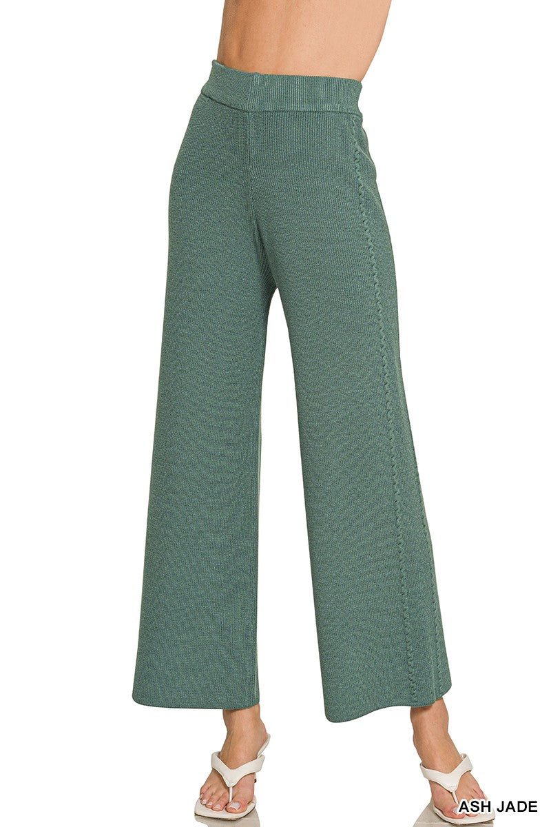 Green wide-leg pants worn by a person on a white background