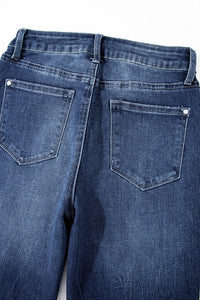 Close-up of blue jeans with a focus on the back pocket on a white background