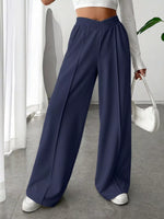 Person wearing navy wide-leg pants in a minimal indoor setting