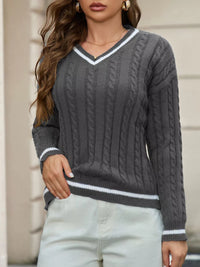 Person wearing a gray cable knit sweater with white trim
