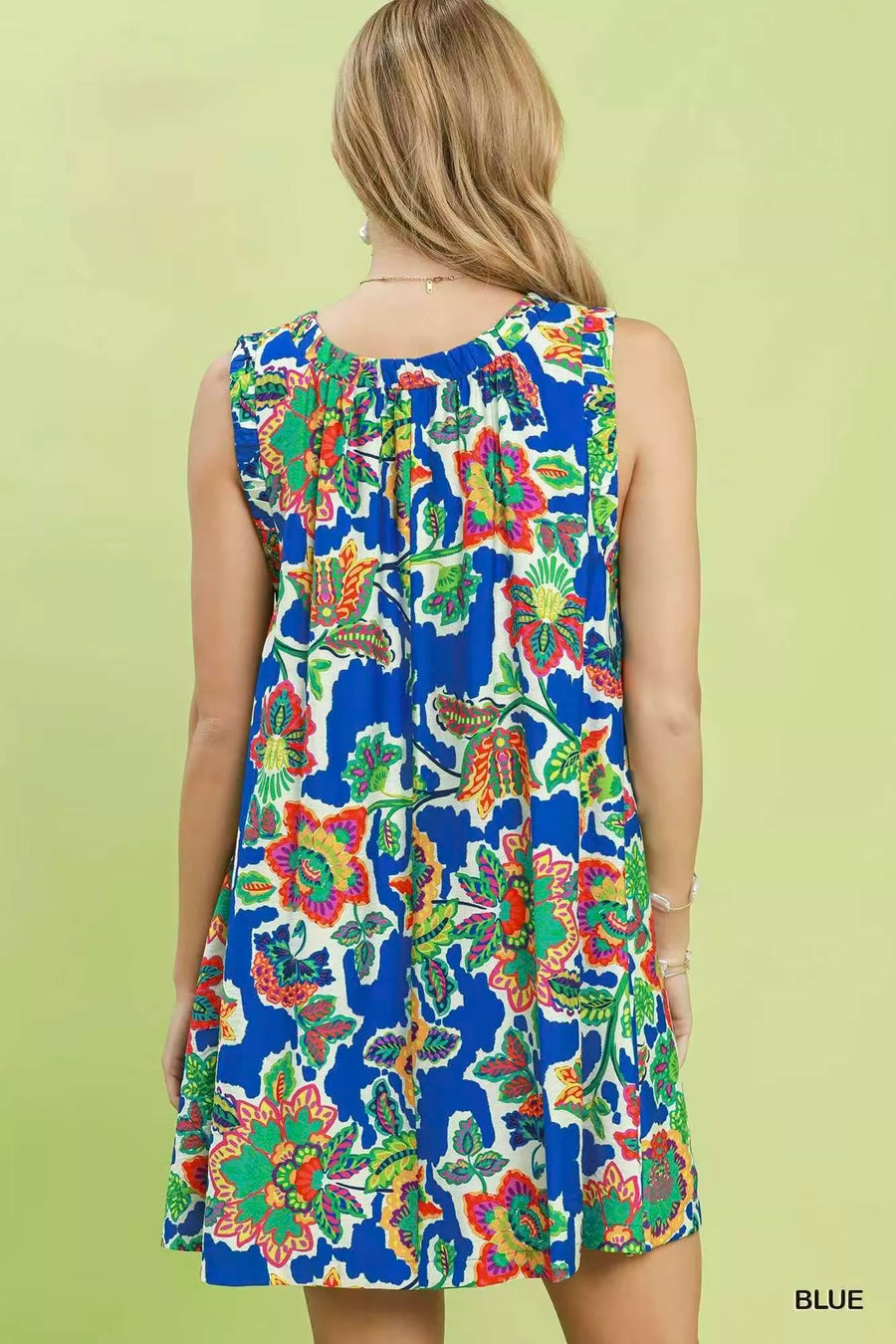 Woman wearing a colorful floral dress on a light green background
