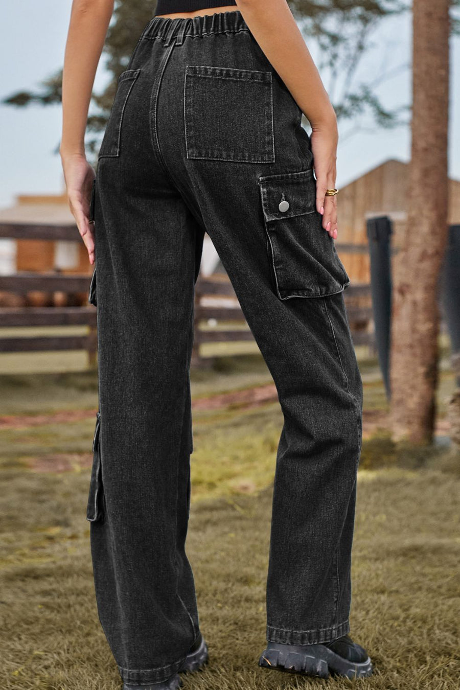Person wearing black cargo pants standing outdoors with a blurred background