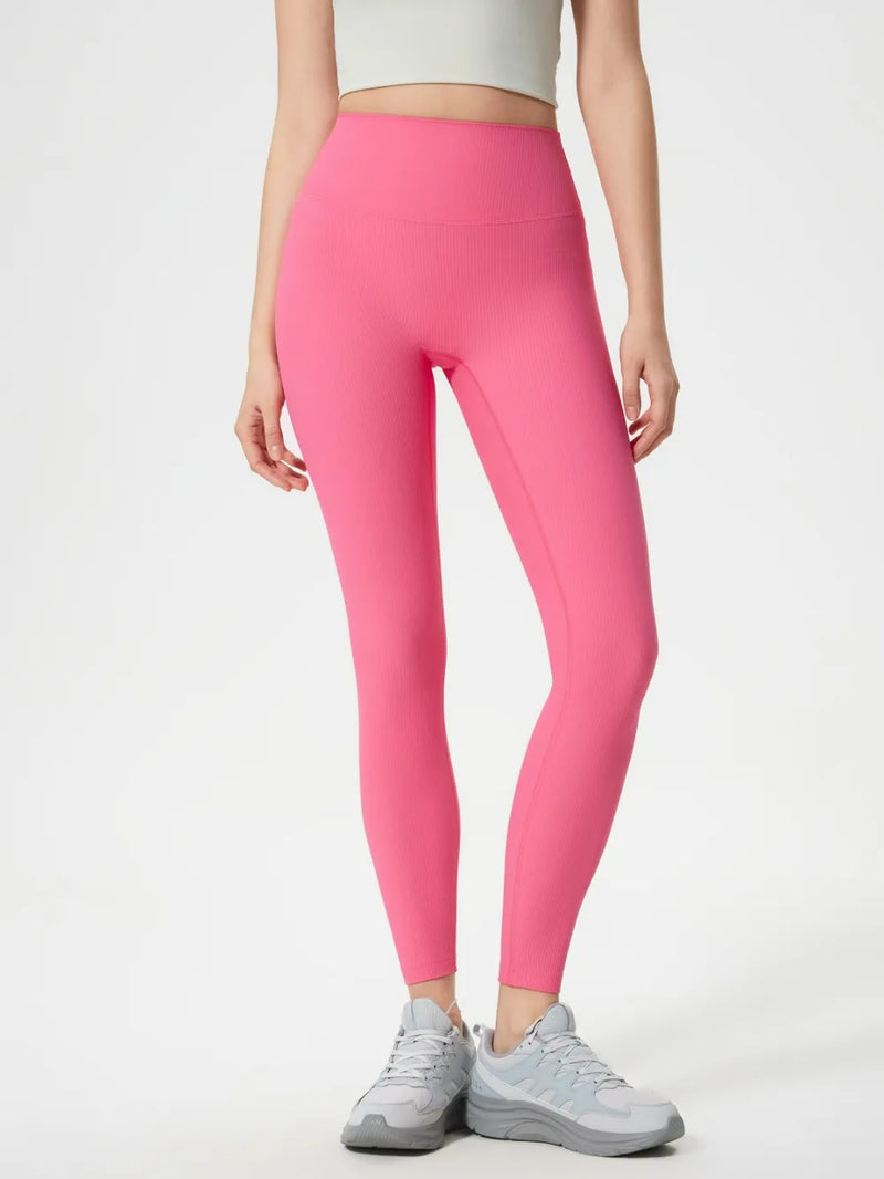 Person wearing bright pink leggings on a white background