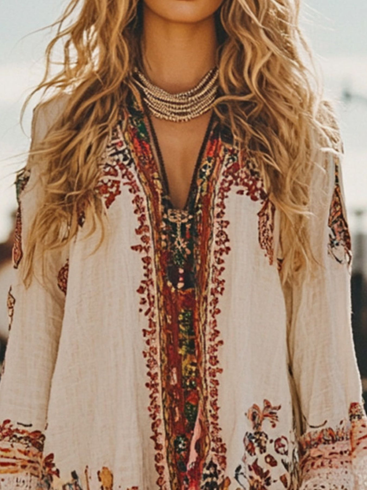 Person wearing a bohemian-style dress with intricate patterns and embroidery.