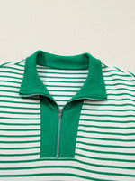 Green and white striped shirt with a collar and zipper on a beige background