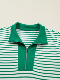 Green and white striped shirt with a collar and zipper on a beige background