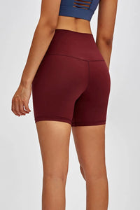 Maroon athletic shorts worn by a person on a white background