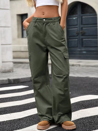 Person wearing green cargo pants standing on a street.