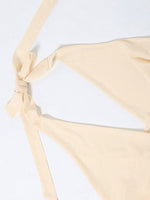 Beige bikini bottom with a tie detail on a white background