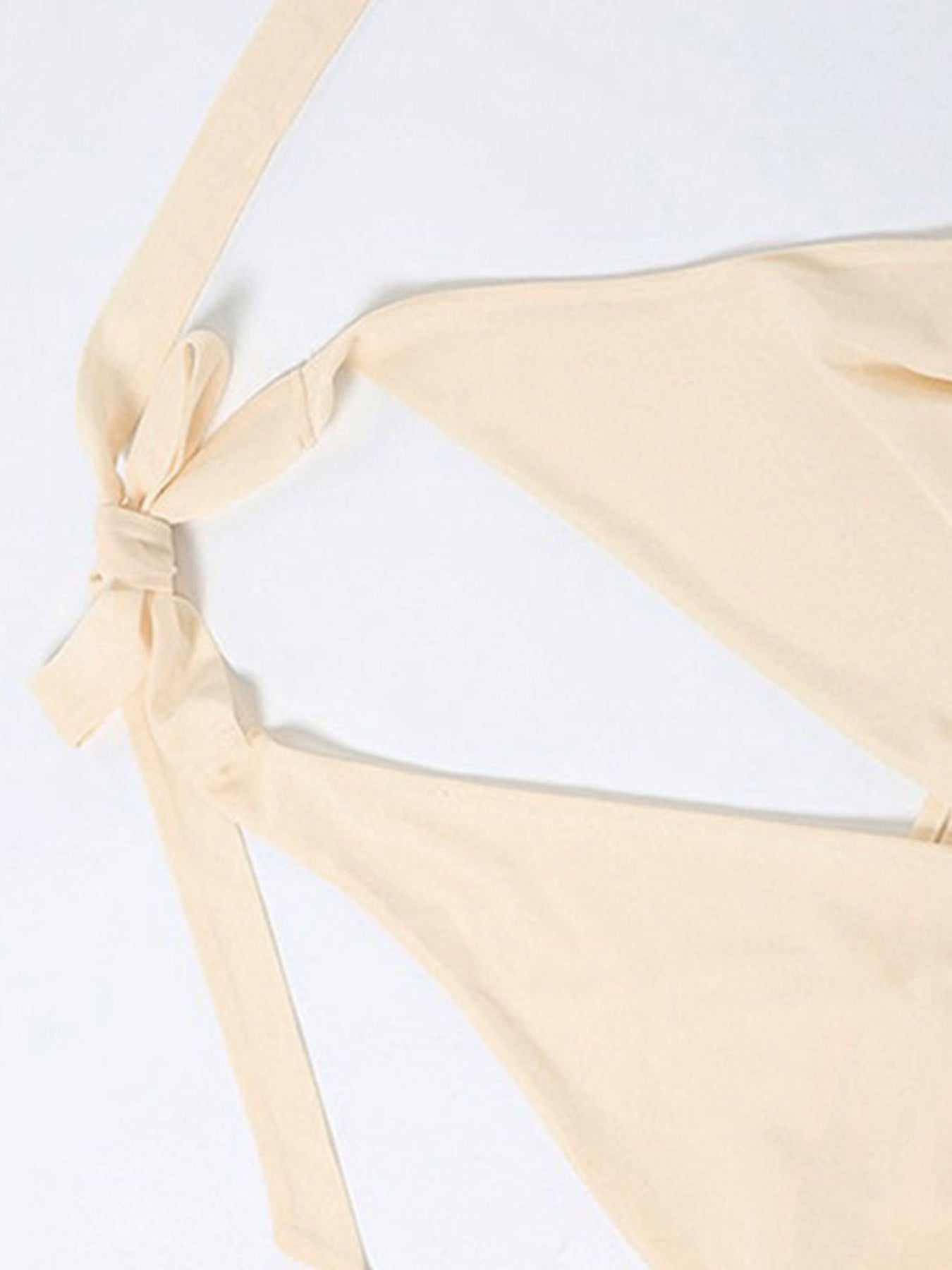 Beige bikini bottom with a tie detail on a white background