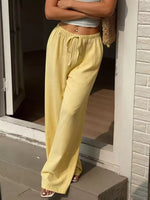 Person wearing yellow pants standing on a porch.
