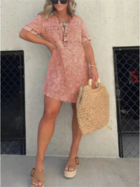 Woman wearing a pink floral dress holding a straw bag against a plain background