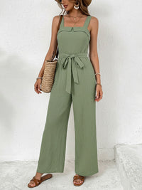 Woman wearing a green jumpsuit with a white background