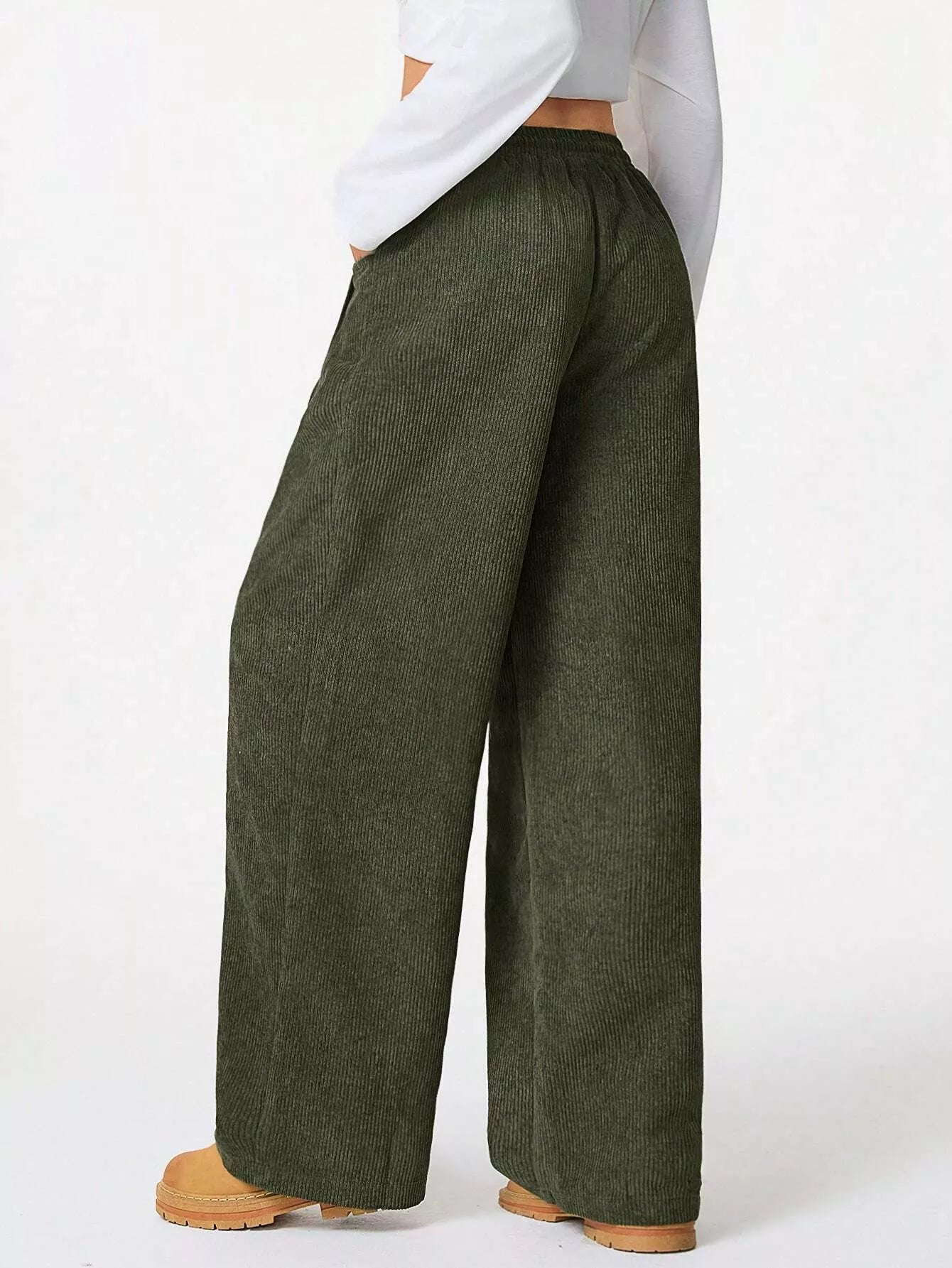 Person wearing green wide-leg pants on a white background