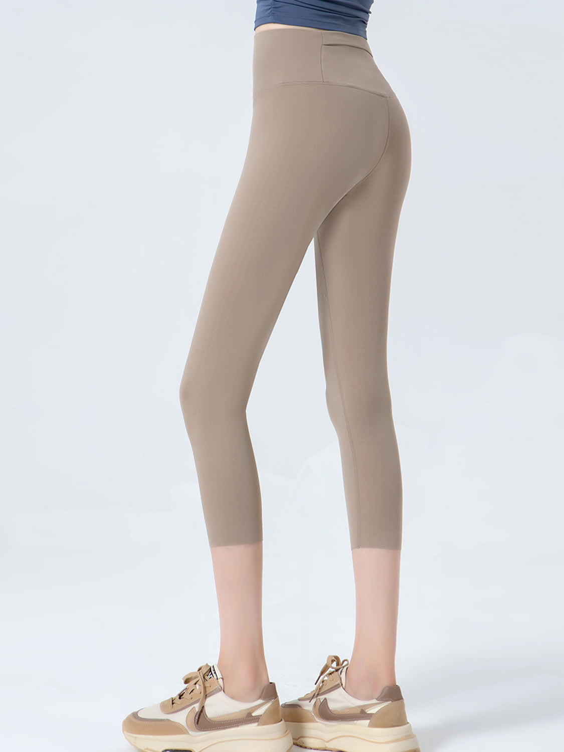 Beige leggings worn by a person on a white background